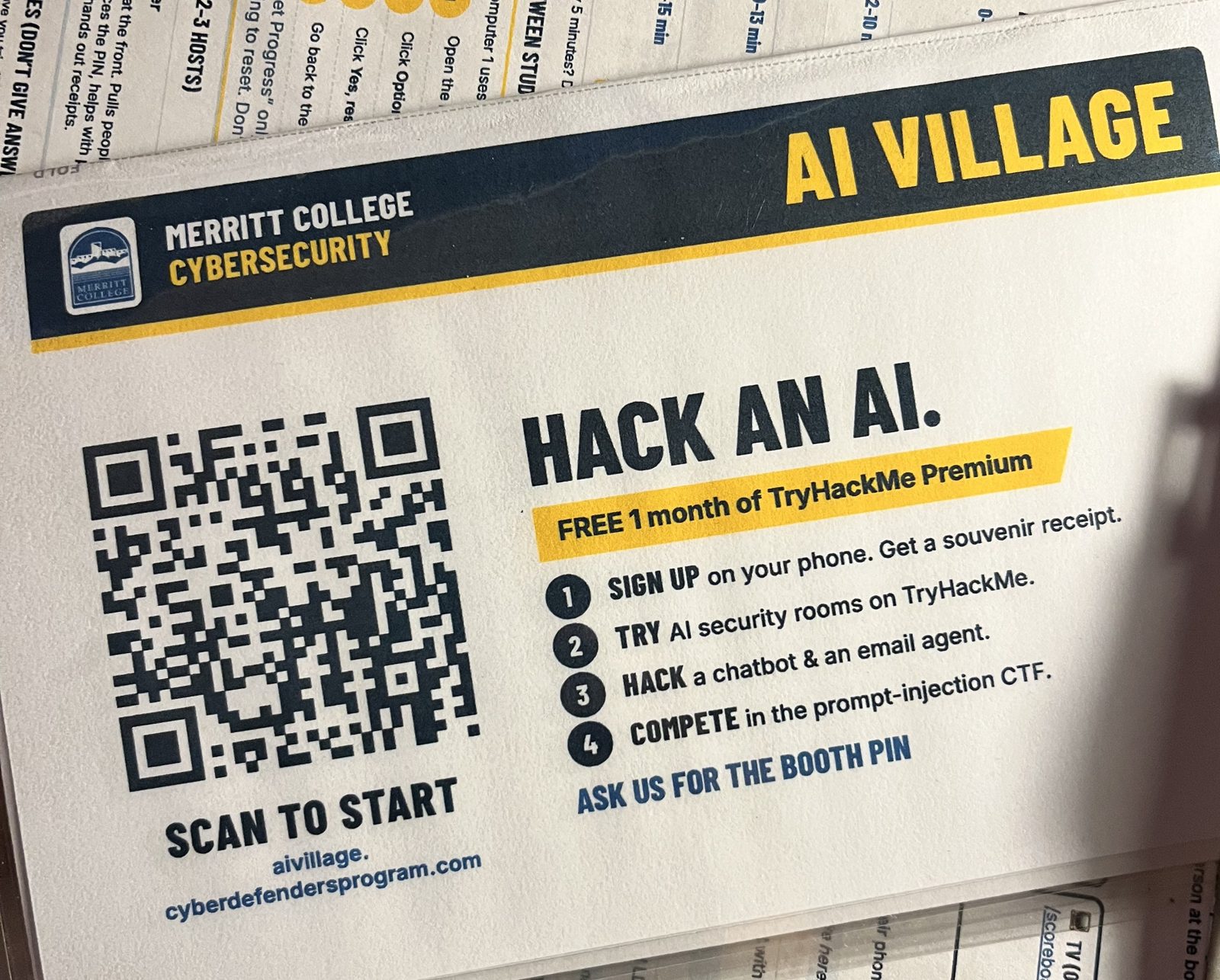 AI Village table tent: Hack an AI. Free 1 month of TryHackMe Premium. Scan to start.
